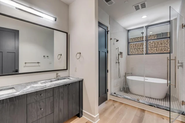 Modern luxuries like a large soaking tub complement the historic character of antique brick and timber beams in the sanctuary of residence 304’s primary bathroom.

#71Wentworth #CrownOfKingStreet #HistoricCharleston #CharlestonRealEstate